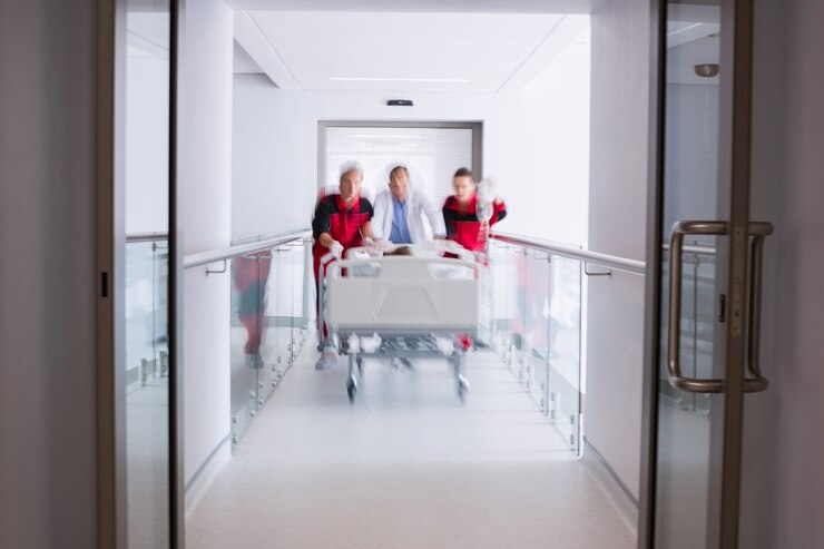 Foto grátis médicos empurrando cama maca de emergência no corredor
