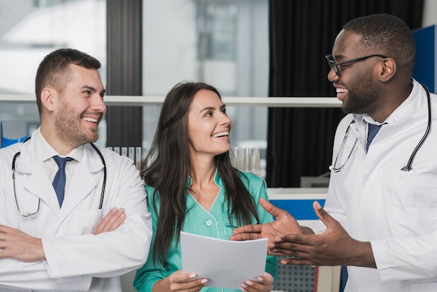 Foto grátis médicos multiétnicos felizes com documento