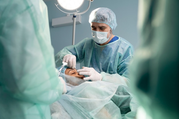 Médicos na sala de cirurgia realizando rinoplastia