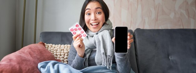 Foto grátis médicos on-line e mulheres coreanas sorridentes da área de saúde mostram a tela do celular e a captura de medicamentos