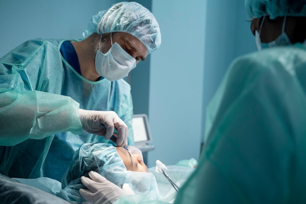 Médicos realizando rinoplastia na sala de cirurgia
