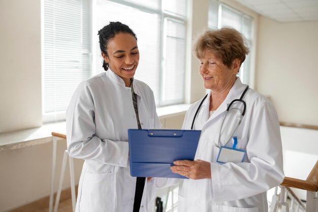Médicos sorridentes de tiro médio conversando no trabalho