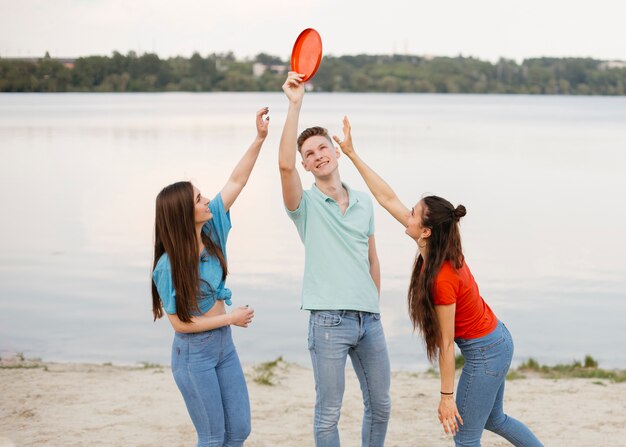 Médio, tiro, amigos, tocando, com, frisbee