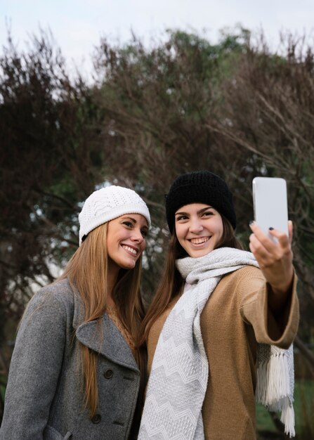 Médio, tiro, dois, sorrindo, mulheres, levando, um, selfie