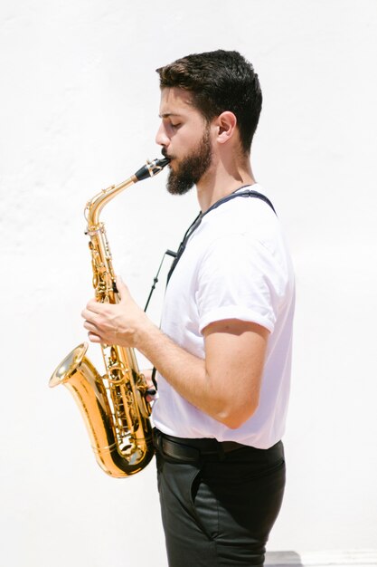 Médio, tiro lateralmente, músico, tocando, saxofone