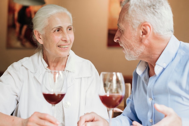 Foto grátis médio, tiro, par, bebendo, vinho, em, restaurante