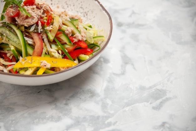 Meia dose de deliciosa salada de frango com legumes em uma superfície branca manchada com espaço livre