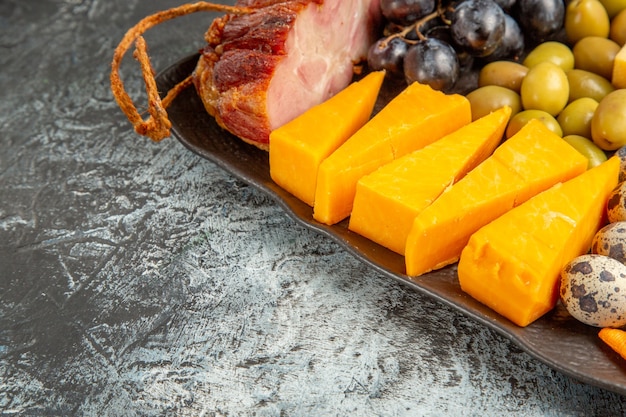 Meia dose do delicioso melhor lanche para vinho servido na bandeja marrom em fundo cinza