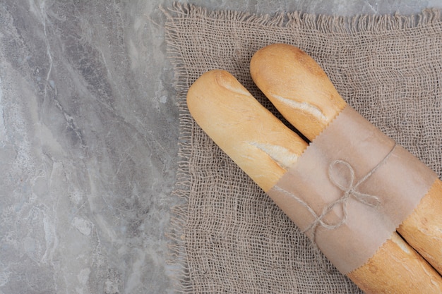 Foto grátis meio corte de baguete francesa em superfície de mármore