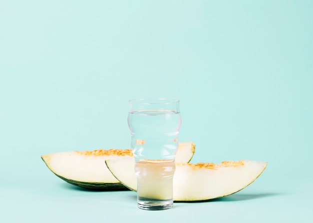 Foto grátis melão fatiado com copo de água