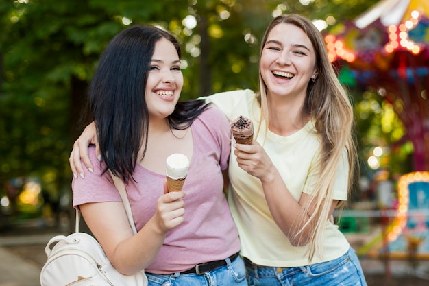 Melhores amigas de tiro médio segurando sorvete