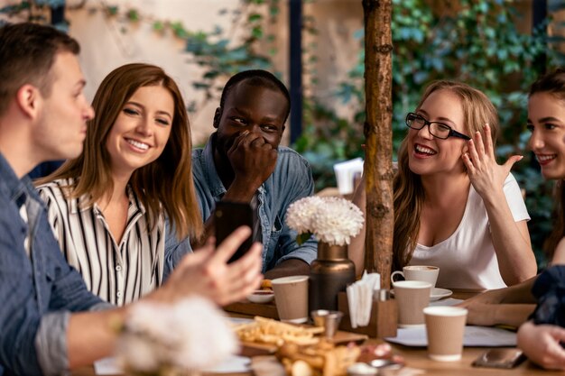 Melhores amigas estão conversando e rindo com saborosos petiscos no terraço