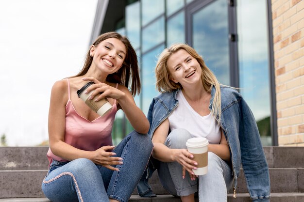 Melhores amigas posam sentadas na escada