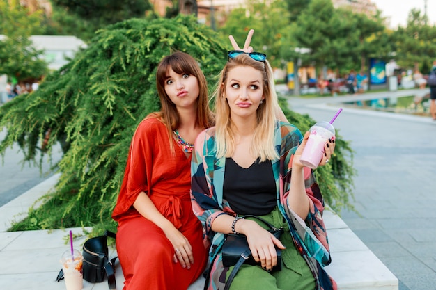 Melhores amigas se divertindo juntos e curtindo férias na ensolarada cidade moderna