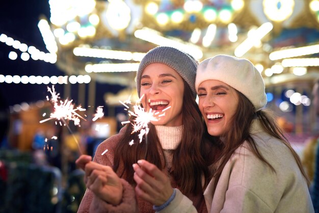 Melhores amigos com fogos de artifício no mercado de Natal