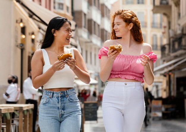 Melhores amigos comendo comida de rua juntos