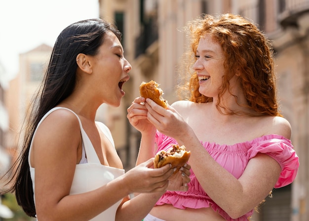 Melhores amigos comendo comida de rua juntos