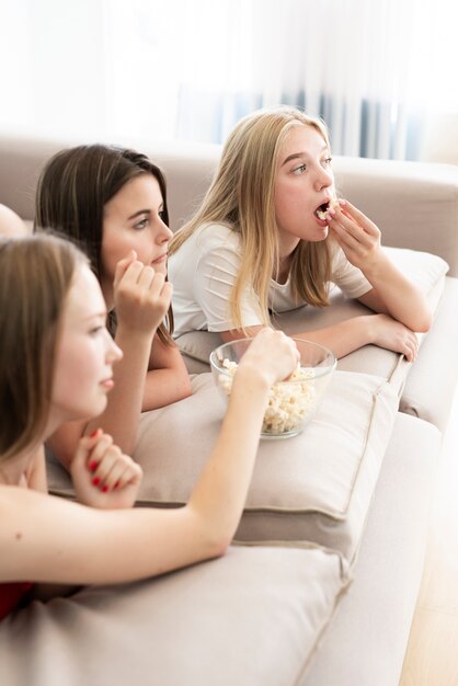 Melhores amigos de lado comendo pipoca