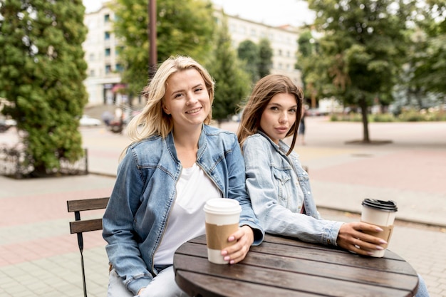 Melhores amigos tomando uma xícara de café lá fora