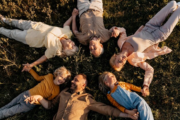 Membros da família em filmagem média deitados na grama