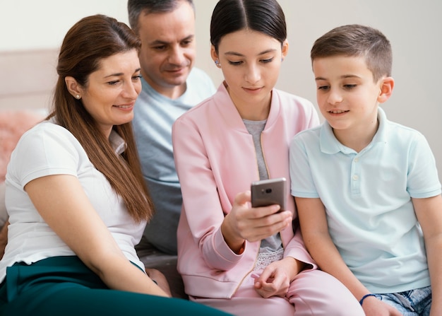 Foto grátis membros da família usando um telefone celular