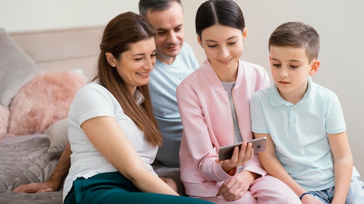 Foto grátis membros da família usando um telefone celular
