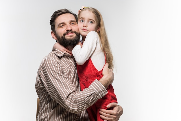 Menina abraçando o pai dela sobre um branco