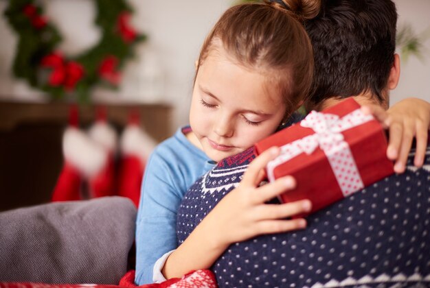 Menina abraçando o pai no Natal