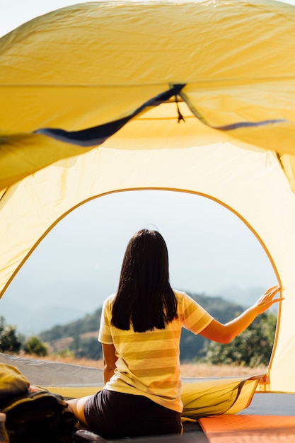 Foto grátis menina acorda de manhã na tenda e vista para a montanha na tailândia