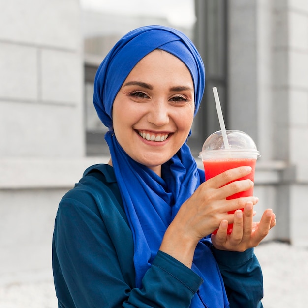 Menina adolescente de azul posando com um smoothie