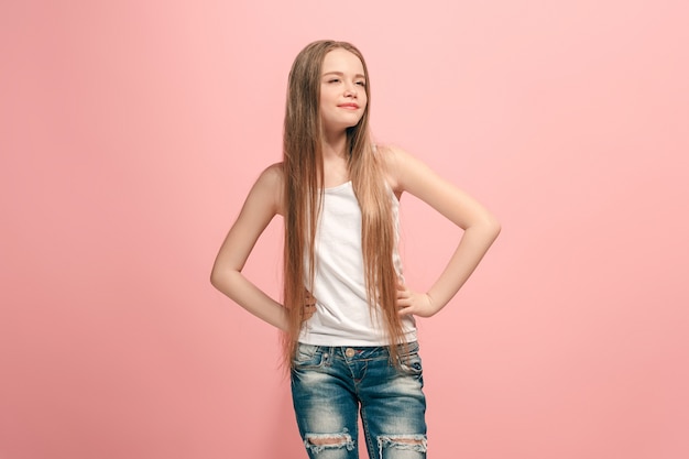 Foto grátis menina adolescente feliz em pé, sorrindo isolado no fundo do estúdio rosa na moda.