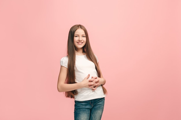 Foto grátis menina adolescente feliz em pé, sorrindo isolado no fundo do estúdio rosa na moda.