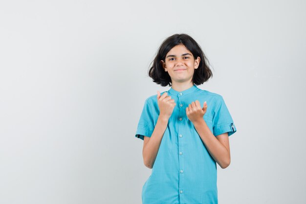 Menina adolescente hesitando em aparecer com o polegar de camisa azul e parecendo complicada