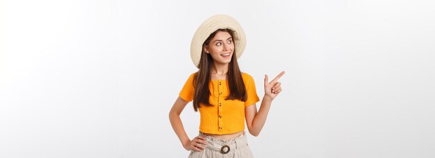 Menina adolescente nas férias de verão surpresa e apontando o dedo no espaço da cópia sobre bac branco isolado