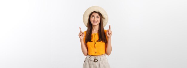 Menina adolescente nas férias de verão surpresa e apontando o dedo no espaço da cópia sobre bac branco isolado