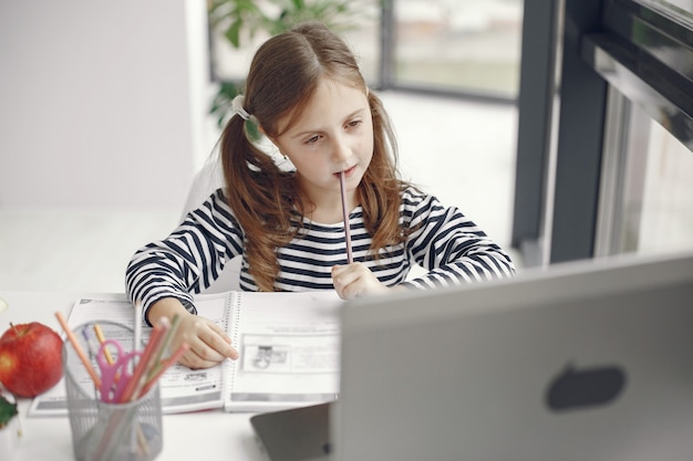 Foto grátis menina adolescente olhando para o laptop. criança no período de isolamento de quarentena durante a pandemia. educação escolar em casa. distanciamento social. teste escolar online.