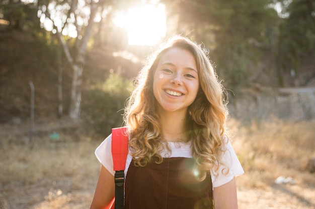 Menina adolescente positiva sorrindo na natureza