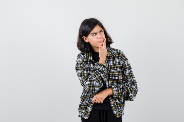 Menina adolescente que sofre de dor de dente, olhando para o lado em uma camisa casual e parecendo dolorida. vista frontal.