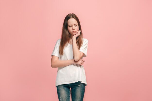 Menina adolescente séria, triste, duvidosa e pensativa no estúdio.