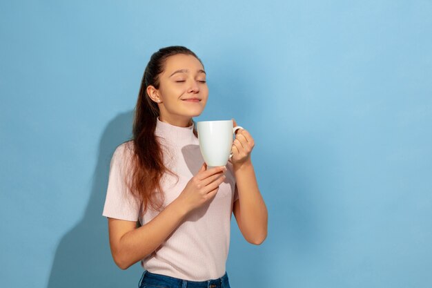 Menina adolescente tomando café