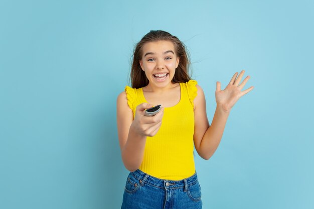 Menina adolescente usando controle remoto da TV