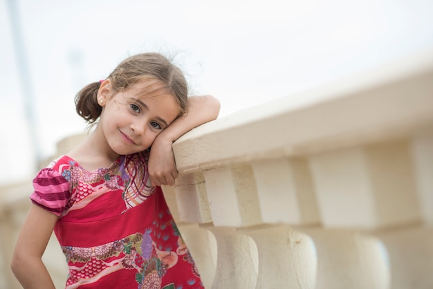 Menina adorável penteada com tranças ao ar livre.