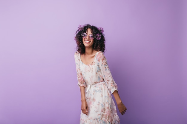 Foto grátis menina africana inspirada magro rindo. foto interna de uma jovem encaracolada entusiasmada, posando com alliums no cabelo.