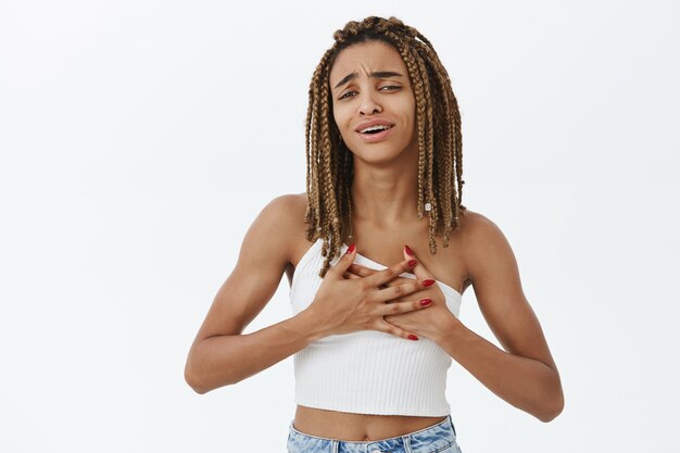 Menina afro-americana sorridente comovida e agradecida olhando para uma coisa comovente