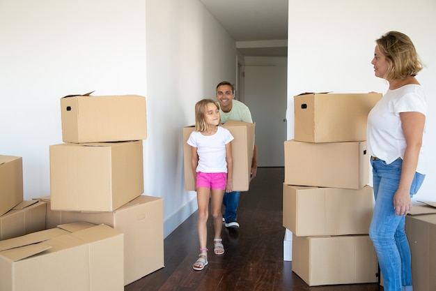 Menina ajudando pais a se mudarem para um novo apartamento