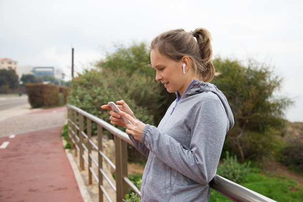 Foto grátis menina alegre alegre parar de correr e verificar o app