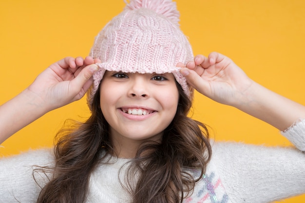 Foto grátis menina alegre, levantando o chapéu do rosto