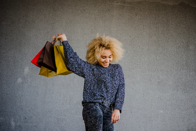 Foto grátis menina alegre posando com bolsas brilhantes