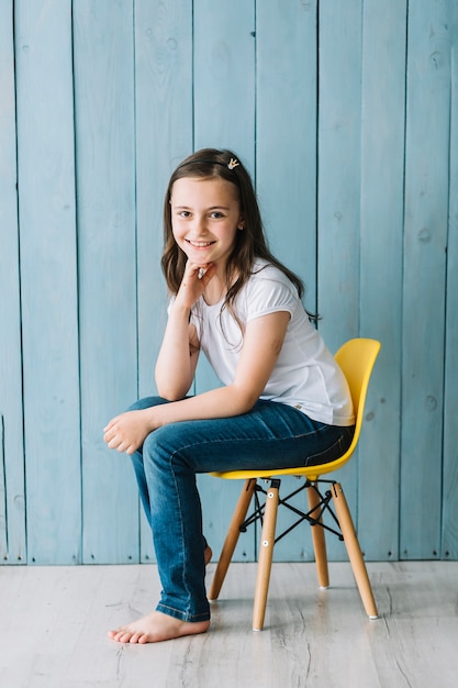 Foto grátis menina alegre sentado na cadeira