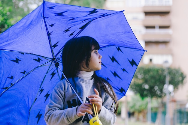 Menina andando com guarda-chuva